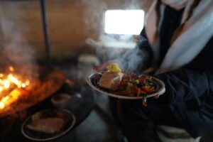 Woman carring plate with salmon an vegetables